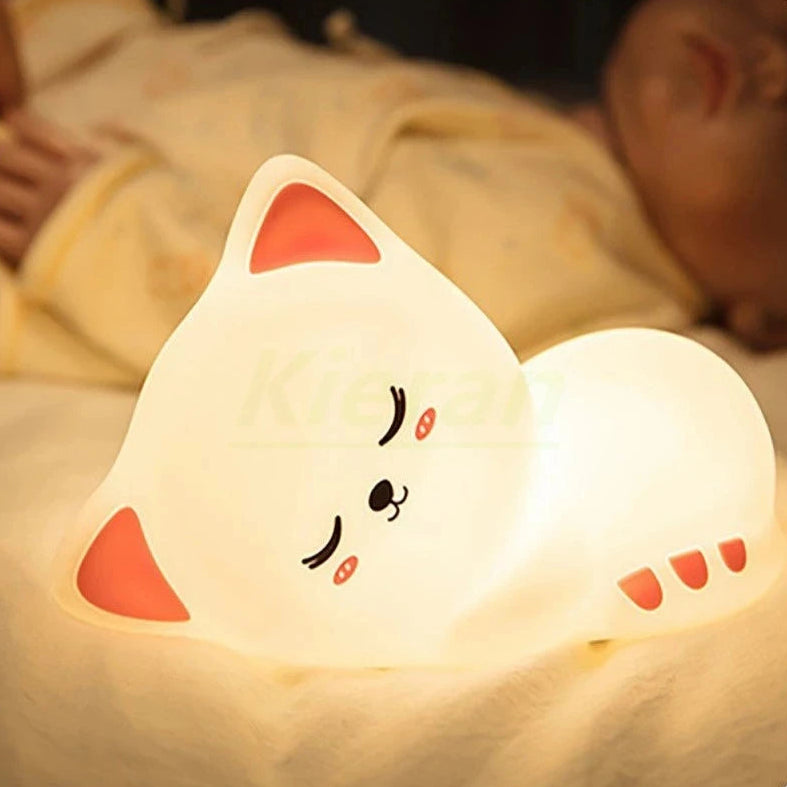 Cat-shaped kawaii night light on a soft surface with a blurred background