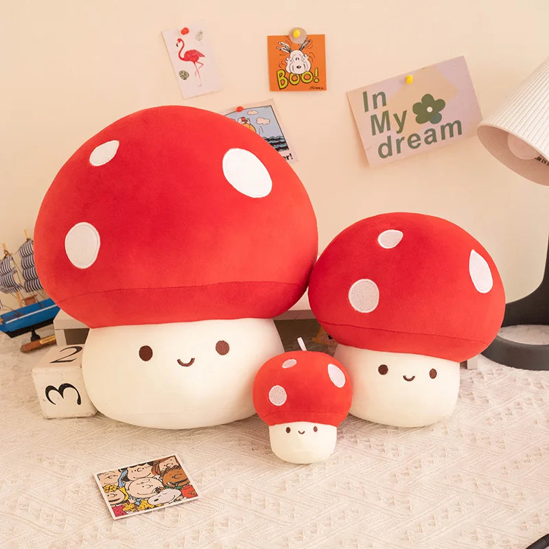 Set of red and white mushroom-shaped plush kawaii toys on a bed with decorative cards in the background.