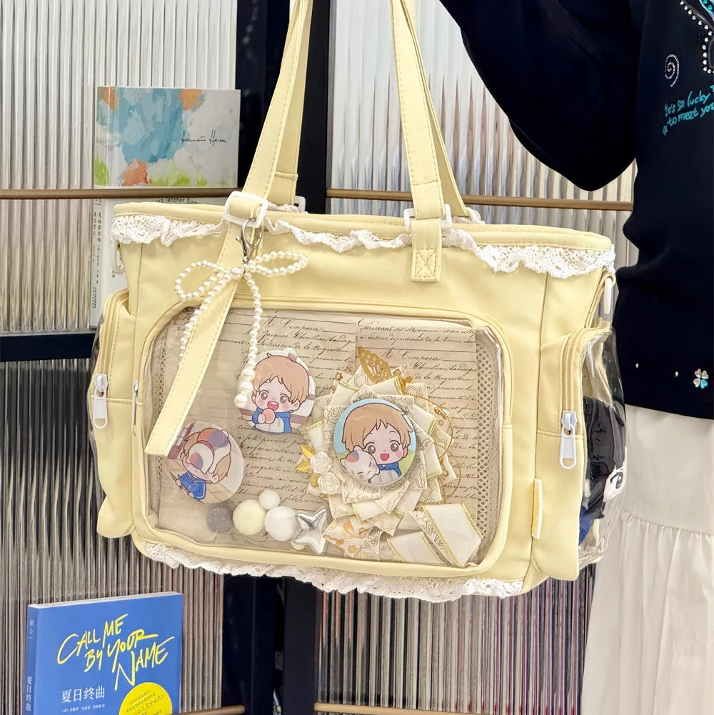 Beige handbag with Kawaii cartoon character designs held by a person against a blurred indoor background.