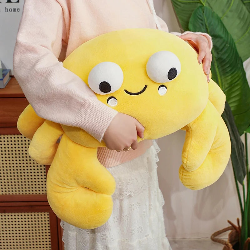 Person holding a yellow kawaii plush toy with a face in a home setting