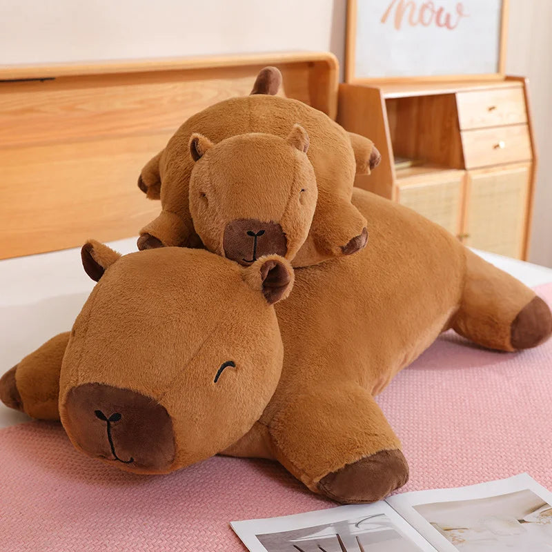 Two brown kawaii teddy bears stacked on a pink surface with a wooden desk in the background.