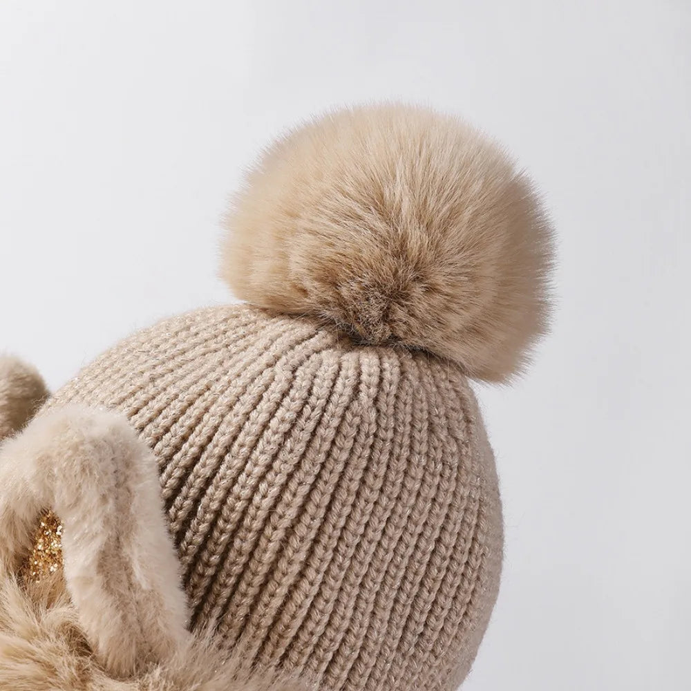 Beige knitted Kawaii beanie with a fluffy pom-pom on a light gray background