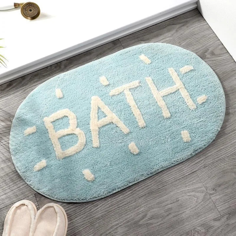 Kawaii light blue bath mat with 'BATH' text on a wooden floor.