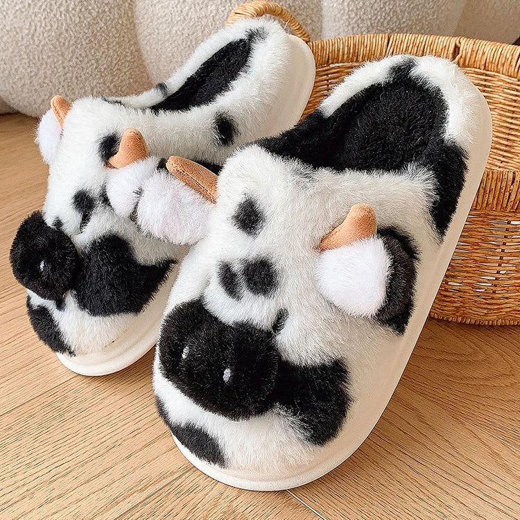 Pair of kawaii cow-patterned slippers on a wooden floor with a wicker basket in the background.