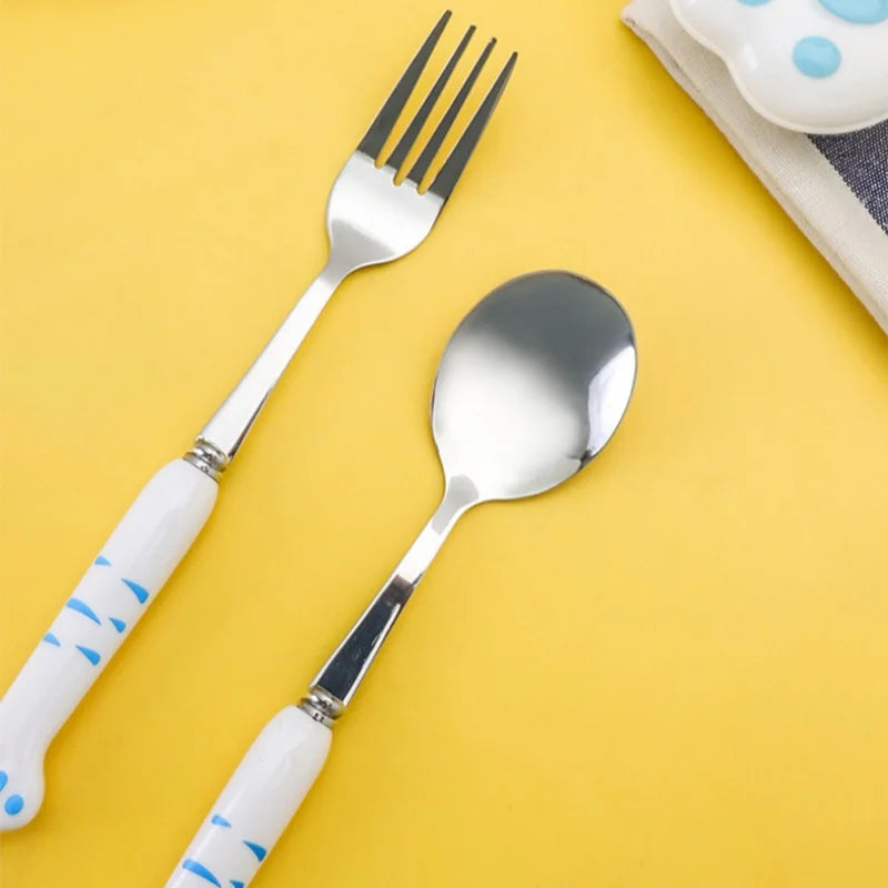 Fork and spoon with white handles featuring blue kawaii cat designs on a yellow background