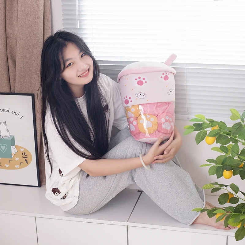 Woman smiling while holding a pink kawaii boba tea plush toy