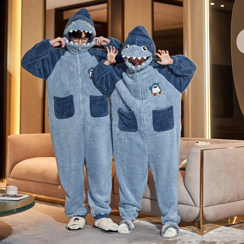 Two people wearing kawaii shark-themed onesies in a living room setting.