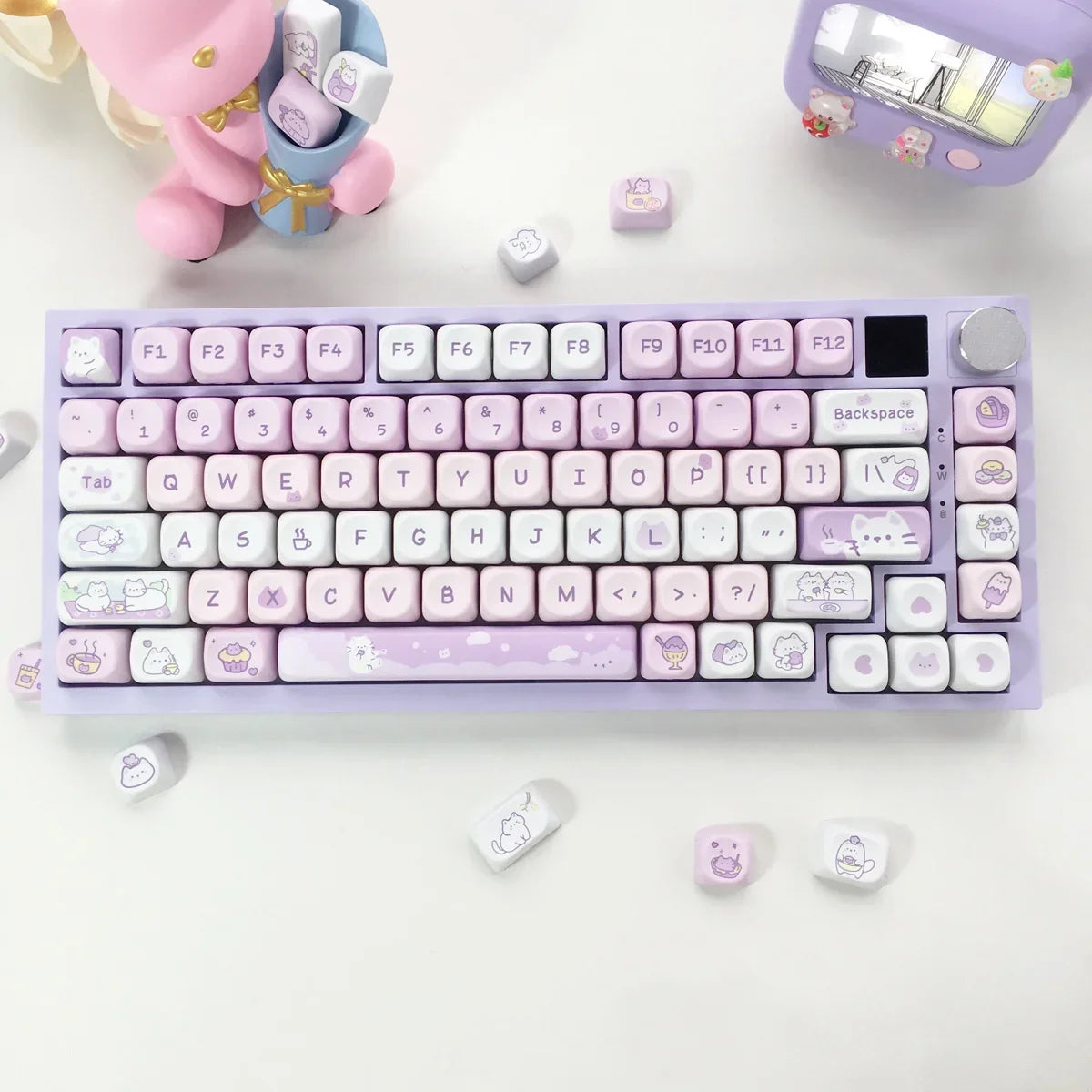 Kawaii themed keyboard with decorative items on a white surface