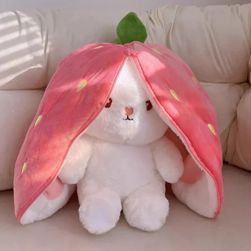 White plush kawaii toy with a strawberry-shaped hood on a beige couch