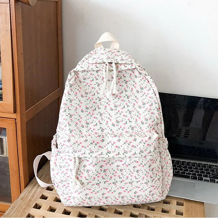Kawaii floral-patterned backpack on a wooden surface with a laptop in the background