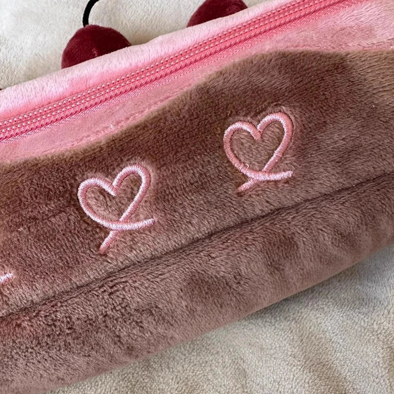 Brown plush pouch with kawaii pink hearts and a pink zipper on a beige background