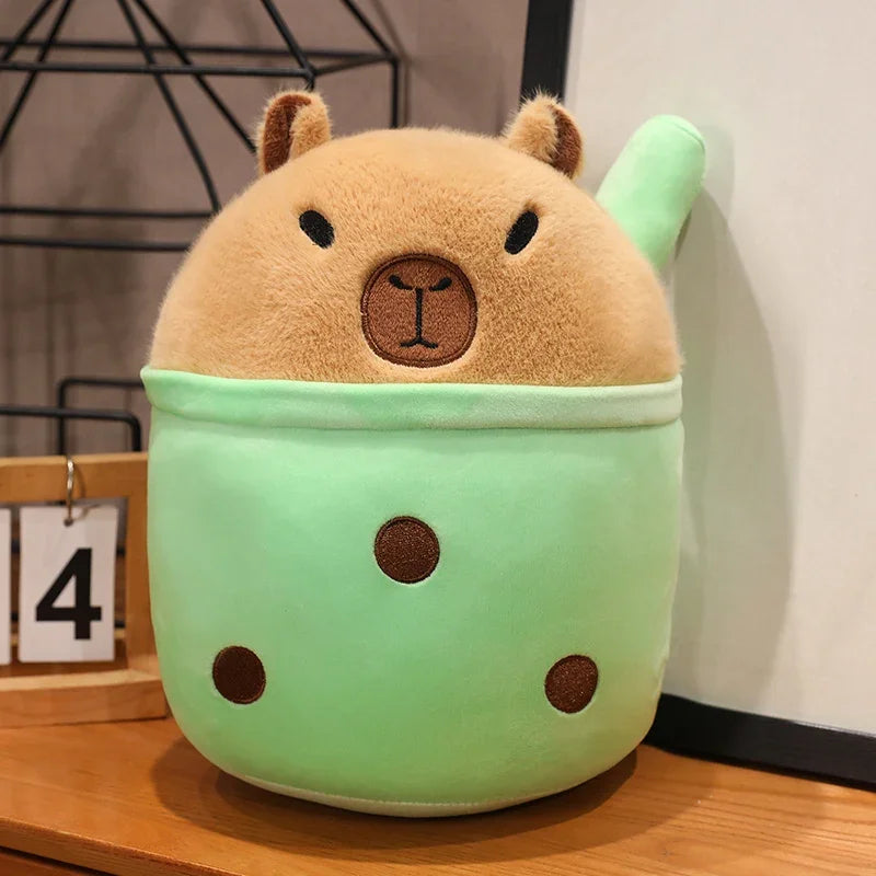 Cute kawaii plush toy with a green body and brown face on a wooden surface.