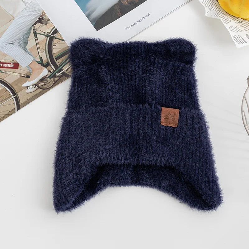 Navy blue knitted Kawaii hat with a brown leather patch on a white surface.