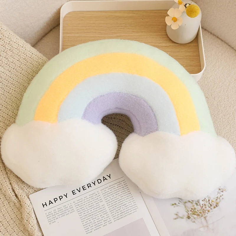 Rainbow-shaped kawaii pillow on a surface with a magazine underneath