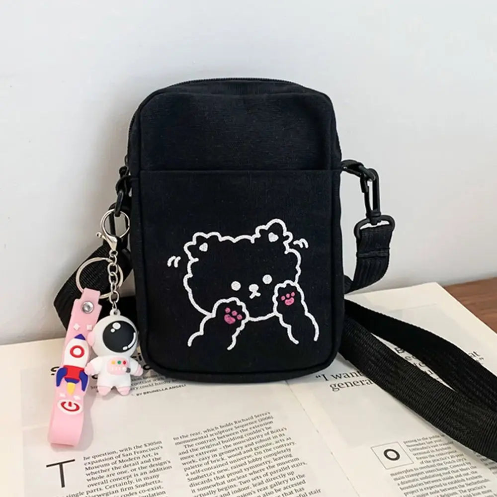 Black crossbody bag with a Kawaii cartoon dog design on a newspaper background
