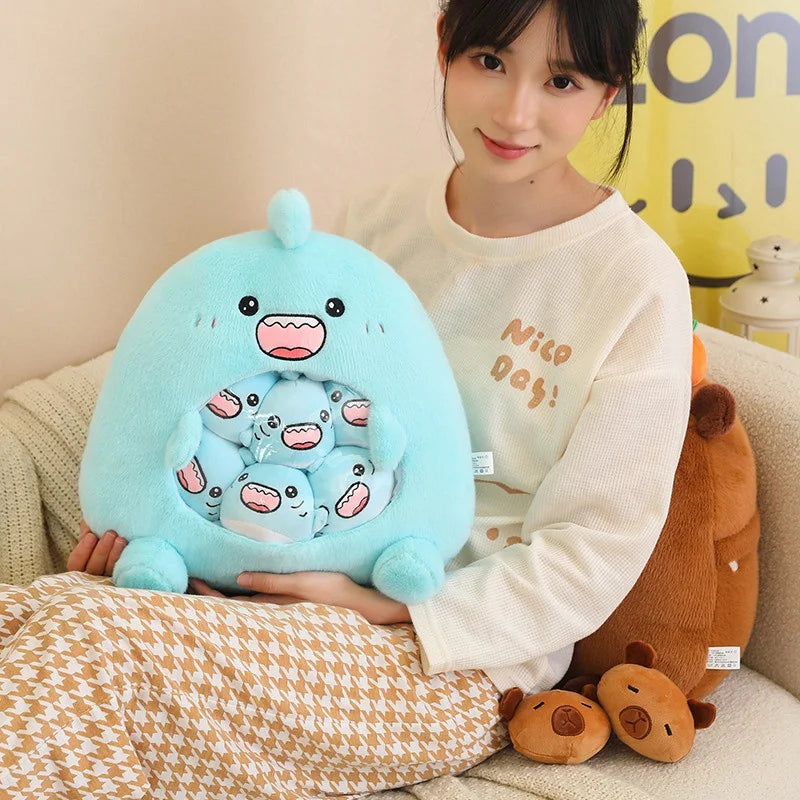Person holding a large blue kawaii plush toy with multiple smaller toys inside, sitting on a couch.