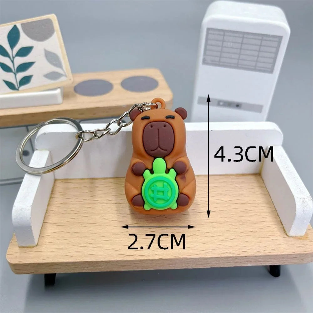 Brown bear kawaii keychain with green turtle shell on a wooden stand, measurements indicated.