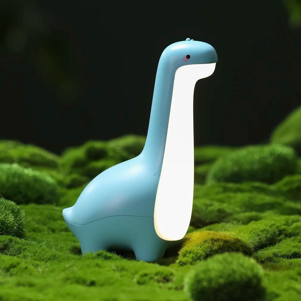Blue dinosaur-shaped kawaii night light on a grassy surface