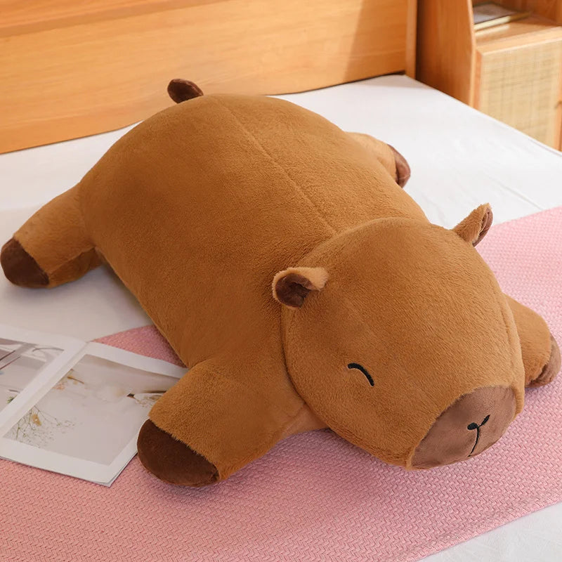 Brown hippo-shaped kawaii pillow on a pink blanket with a wooden headboard in the background