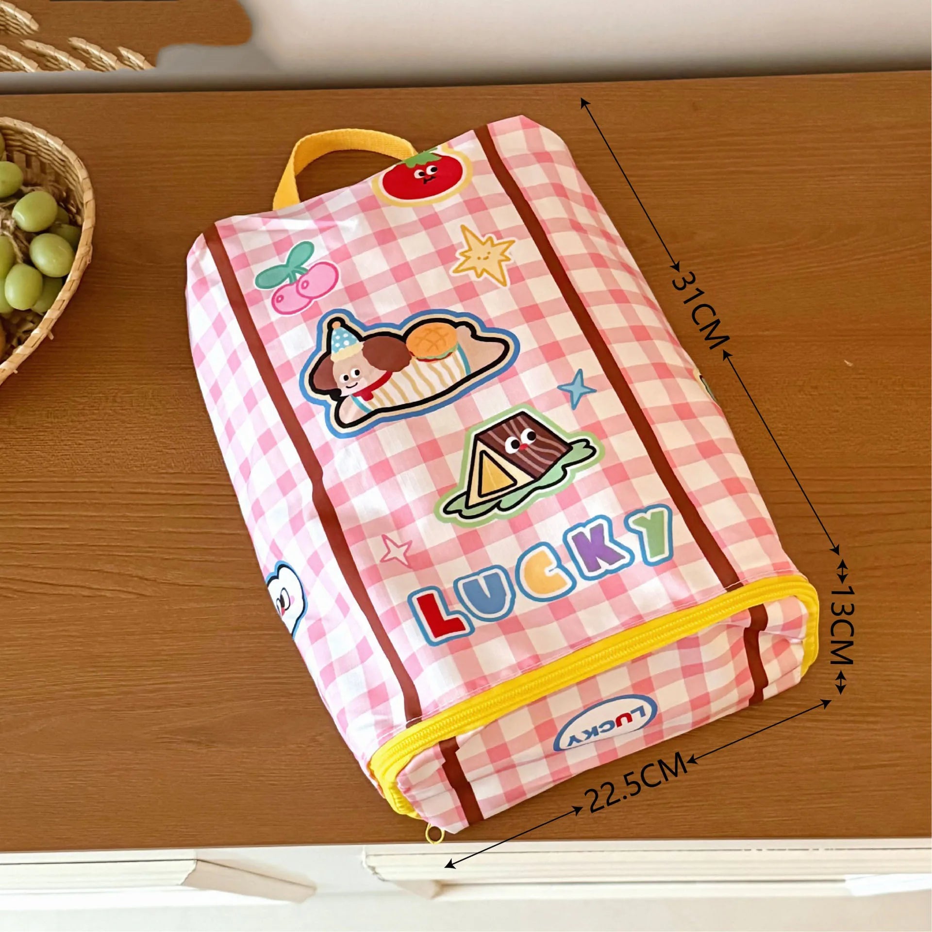 Pink checkered pouch with Kawaii cartoon designs and 'LUCKY' branding on a wooden surface.