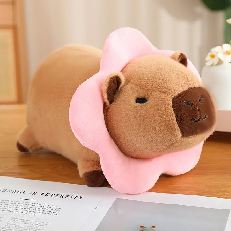 Kawaii plush toy resembling a bear with a pink flower on a wooden surface