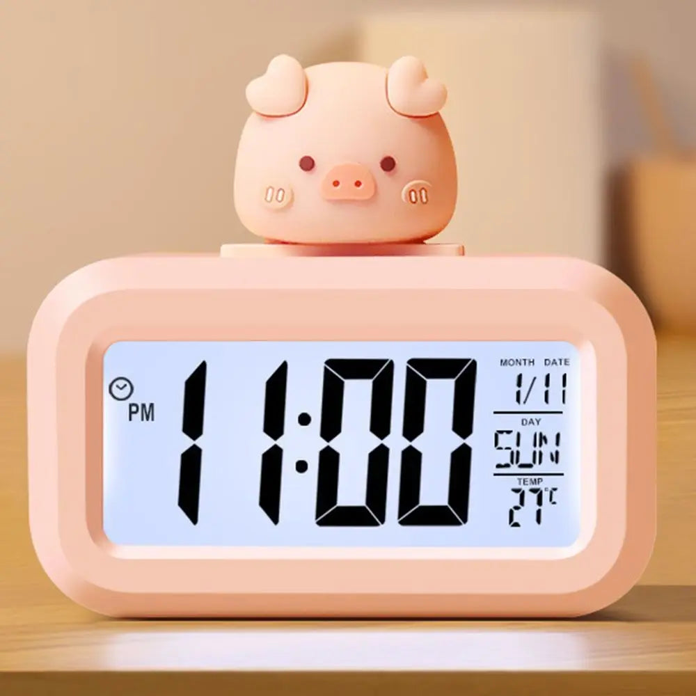 Pink pig-shaped kawaii digital clock on a wooden surface with a blurred background