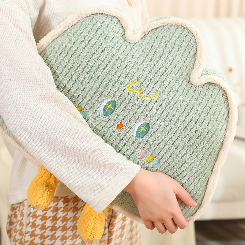 Heart-shaped green kawaii cushion with embroidered design held by a person wearing a white sweater.