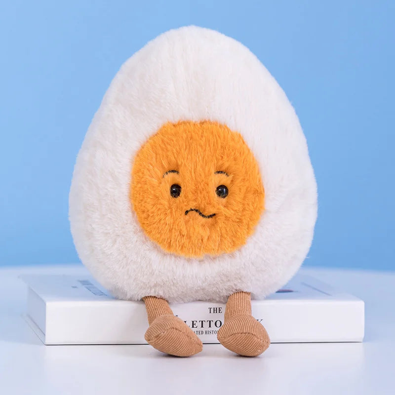 Plush kawaii toy resembling a boiled egg with a sad expression on a blue background