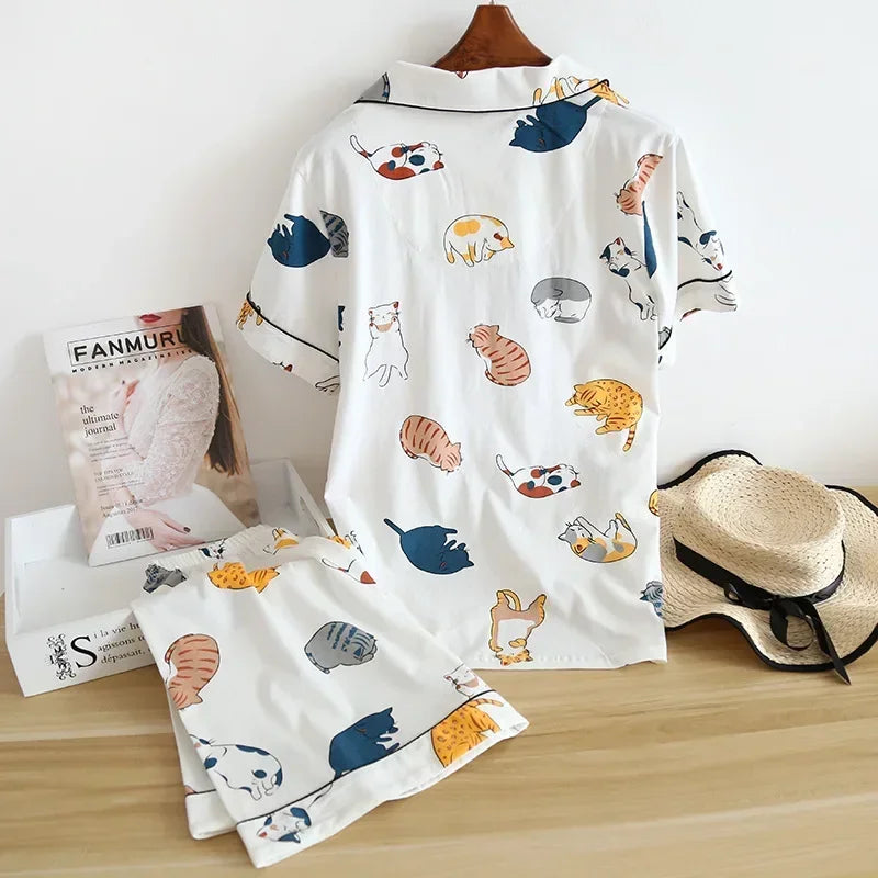 White shirt with kawaii animal pattern on a wooden surface with a hat and box in the background
