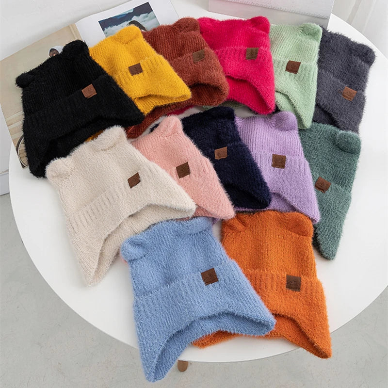 Collection of colorful knitted Kawaii beanies on a white surface