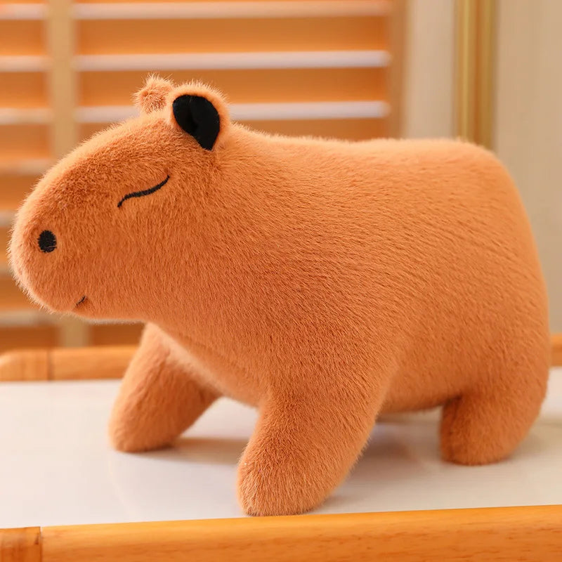 Kawaii plush toy capybara on a wooden surface with a blurred background