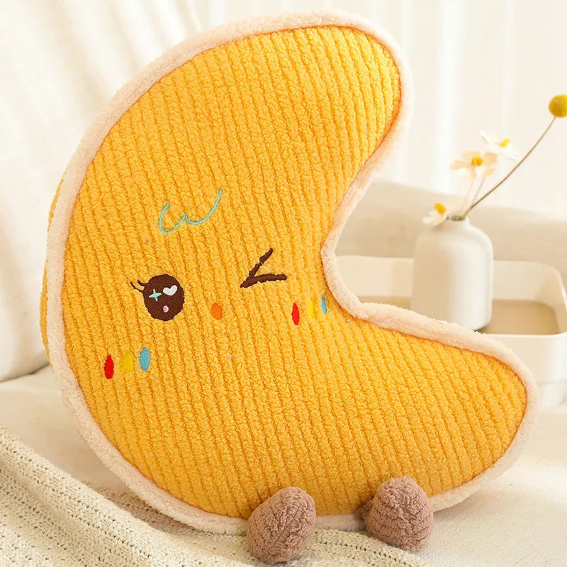 Yellow crescent moon-shaped kawaii pillow with cartoon face on a white surface