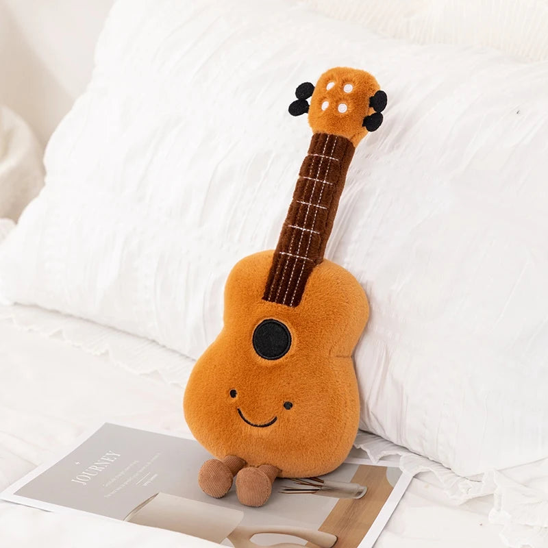 Plush kawaii toy guitar with a smiling face on a white surface
