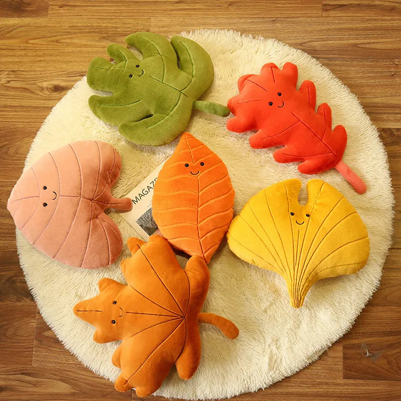 Set of kawaii colorful leaf-shaped cushions on a round white rug.