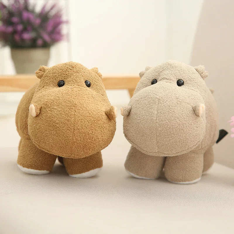 Two kawaii plush hippo toys on a light surface with a blurred background