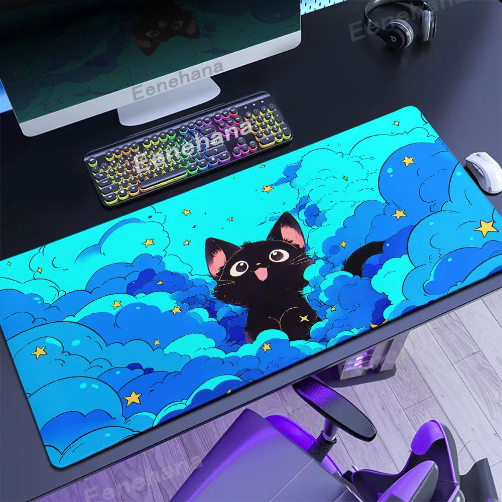 Desk setup with a large mouse pad featuring a Kawaii black cat design, keyboard, and computer monitor.