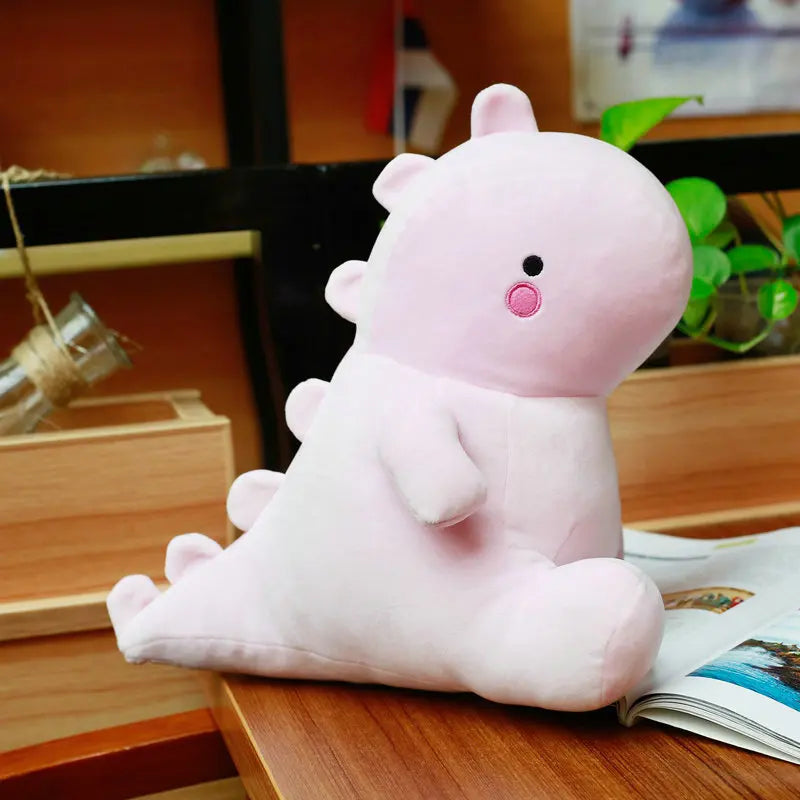 Pink kawaii plush toy on a wooden surface with a blurred background