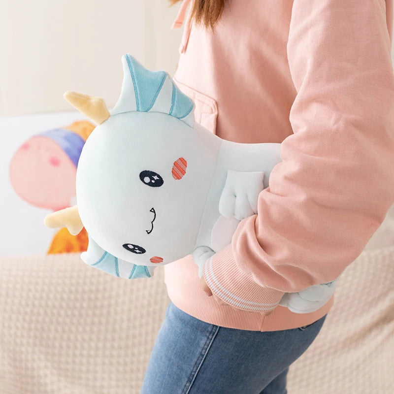Person holding a kawaii plush toy with a cartoon face, wearing a pink sweater and blue jeans.