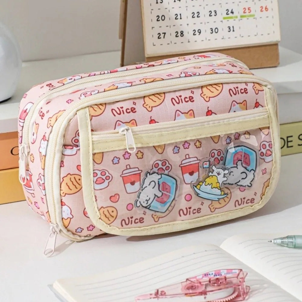 Pink pencil case with kawaii cartoon designs on a desk