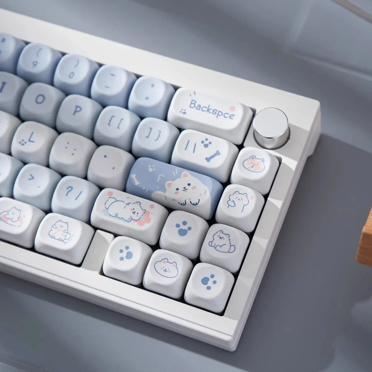 Keyboard with Kawaii keycaps featuring cartoon animals on a gray surface