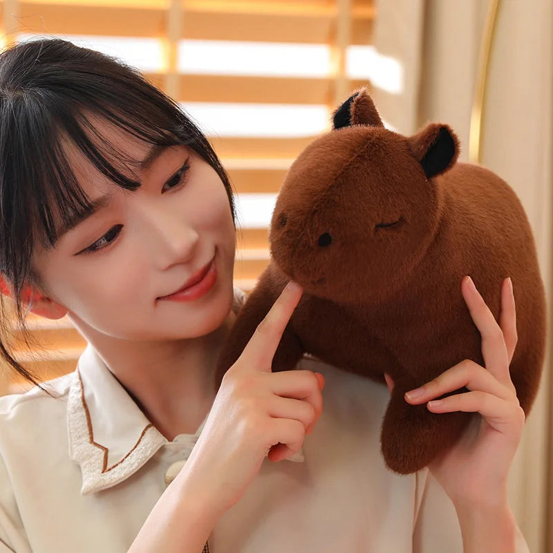 Person holding a brown kawaii plush toy with a blurred indoor background