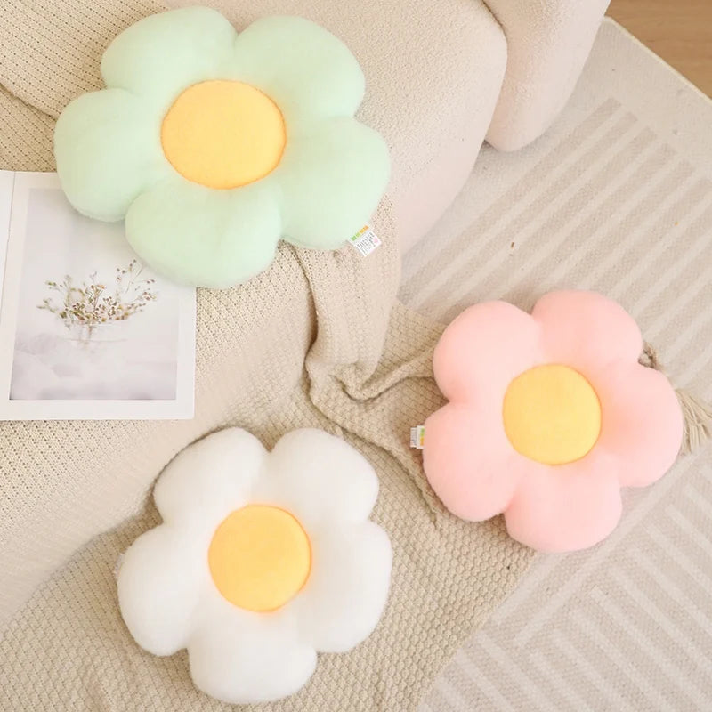 Flower-shaped kawaii cushions in green, white, and pink on a textured surface.