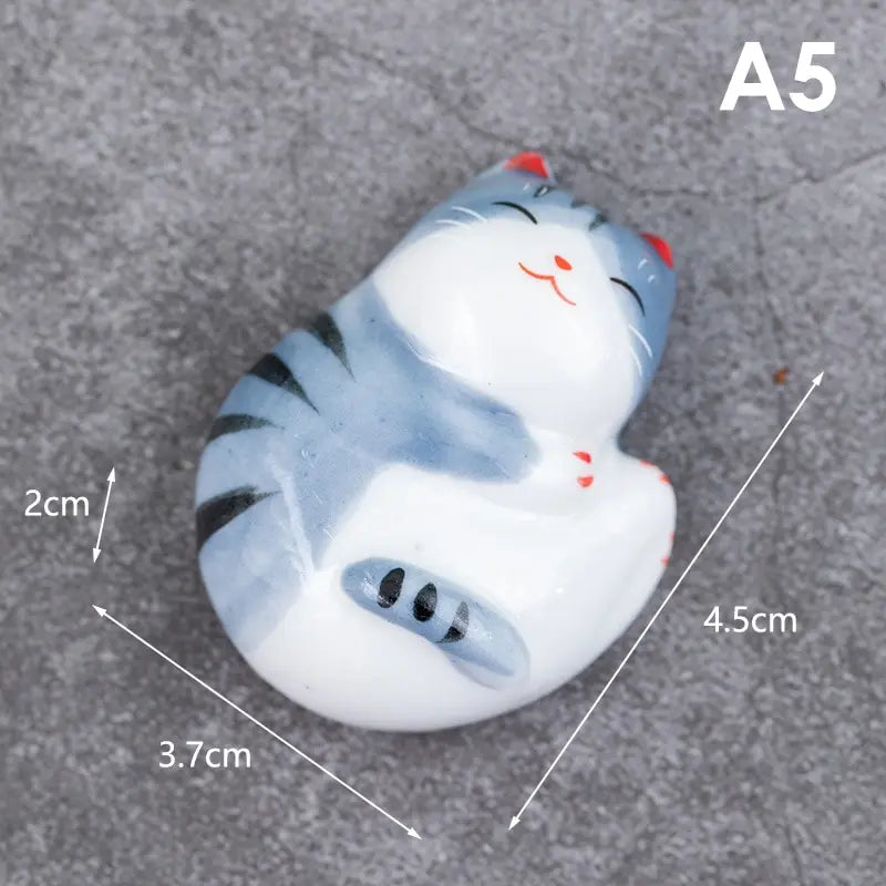 Small figurine of a kawaii cat with dimensions labeled on a gray background