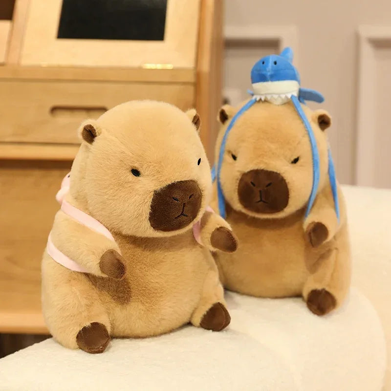 Two kawaii plush toys resembling beavers on a white surface with a wooden frame in the background.