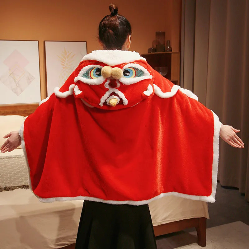 Person wearing a red cape with a kawaii cartoonish face design indoors.