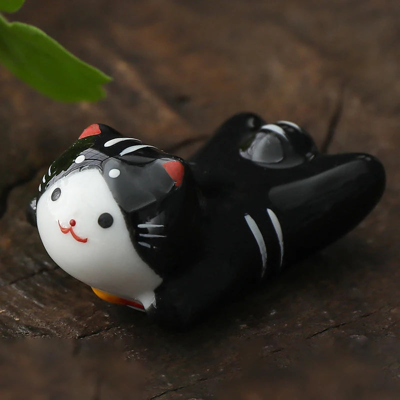 Black and white kawaii cat-shaped object on a wooden surface