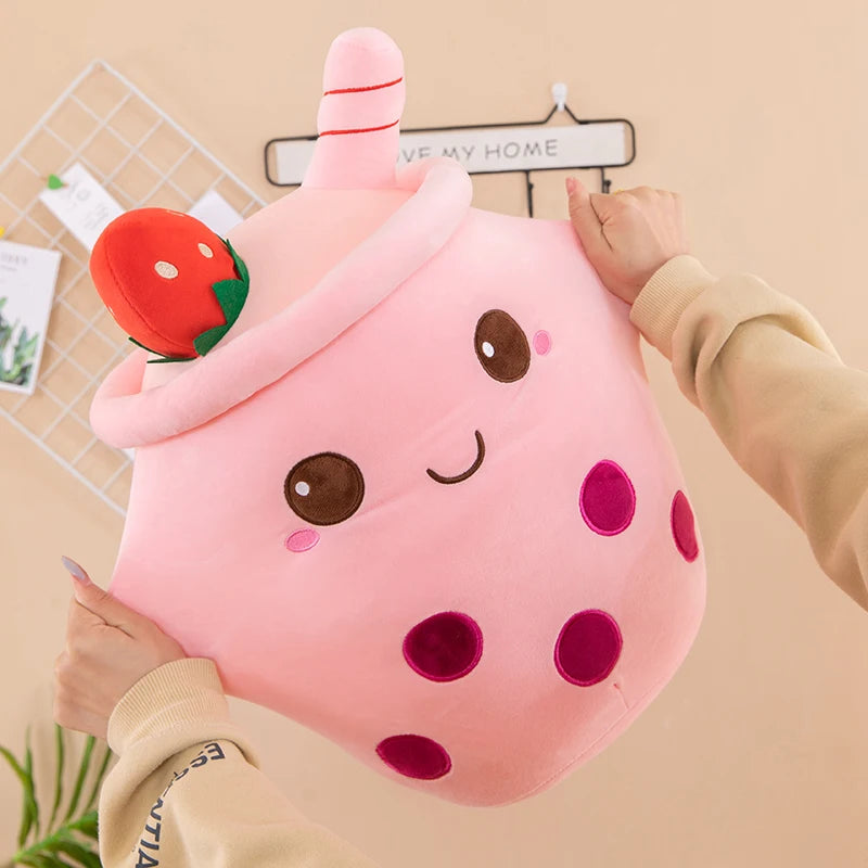 Woman stretching out a kawaii plush toy in the shape of boba tea