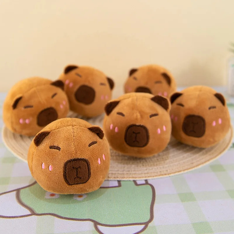 Set of brown kawaii plush toys resembling animal faces on a checkered tablecloth.