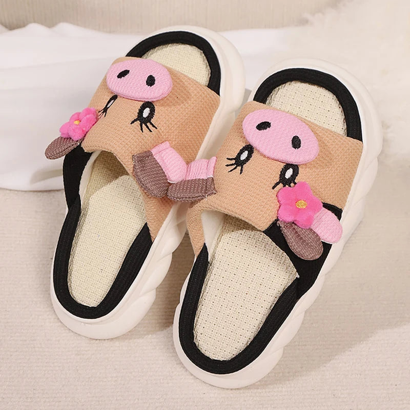 Pair of kawaii cartoon slippers with pink flowers and black accents on a light background