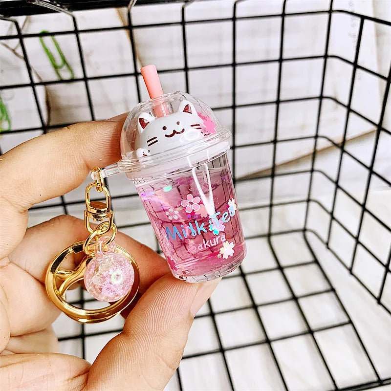 Pink kawaii cartoon character keychain with a small cup and straw against a grid background